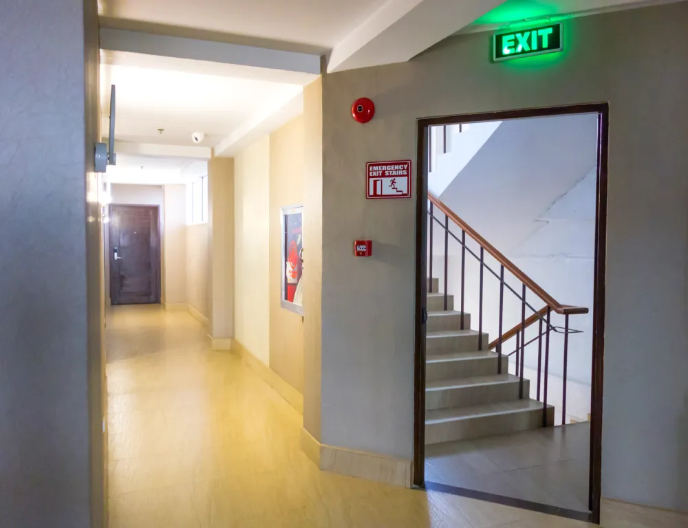 Illuminated exit sign above a stairwell door