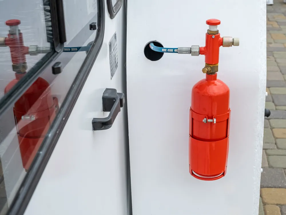Red vehicle fire suppression cylinder mounted inside a vehicle compartment