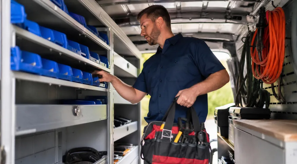 Technician organizing parts on shelves in a service van