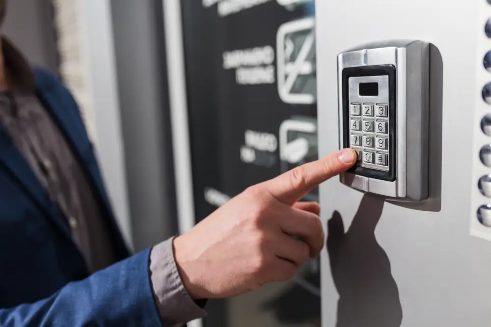 Person entering a code on a wall-mounted access control keypad
