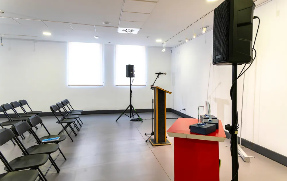 Empty conference room with chairs, a podium, and speakers