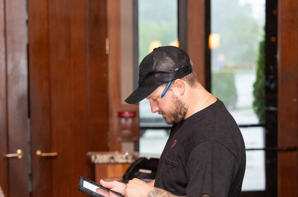 Technician reviewing inspection notes on a tablet in an office